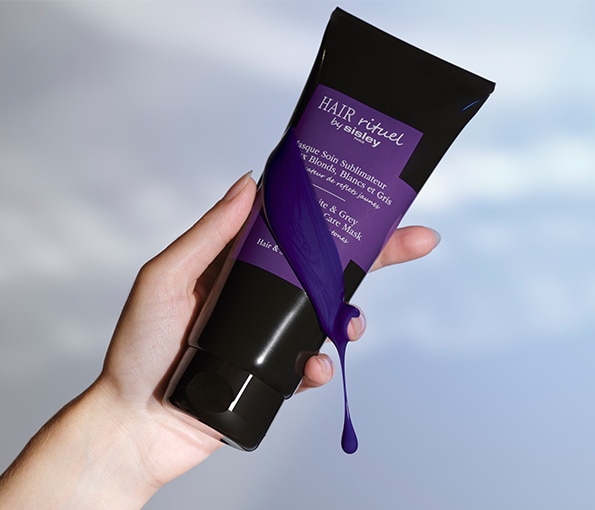 Fialová maska na vlasy Hair Rituel by Sisley pre blond a sivé odtiene, držená v ruke s viditeľnou kvapkou pigmentu